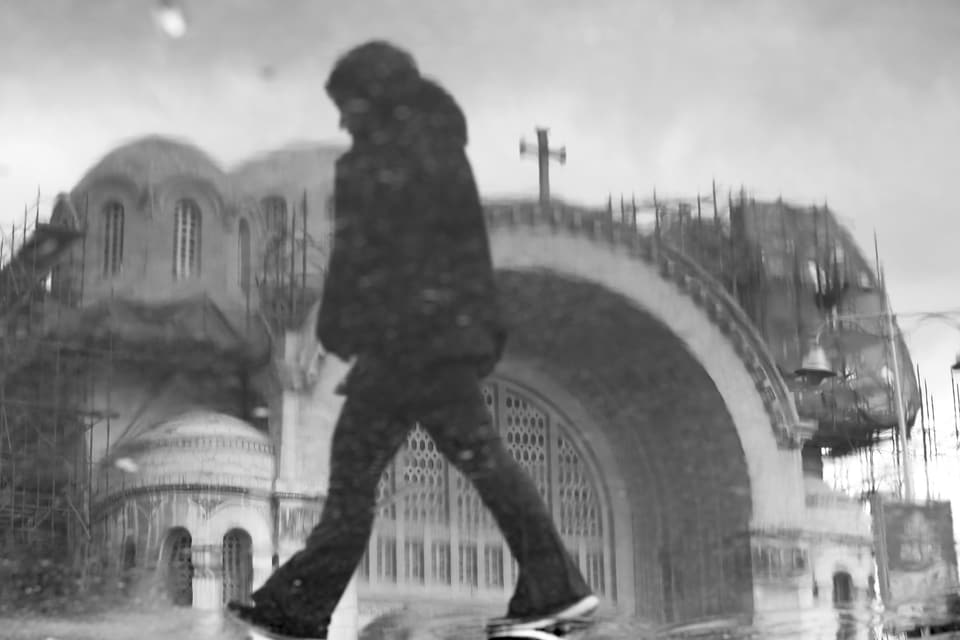 Une silhouette passe devant l’arche d’une église, photographiée par Medhat Soody